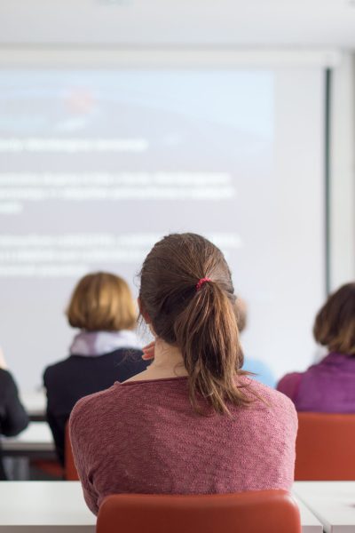 Female,Speaker,Giving,Presentation,In,Lecture,Hall,At,University,Workshop.